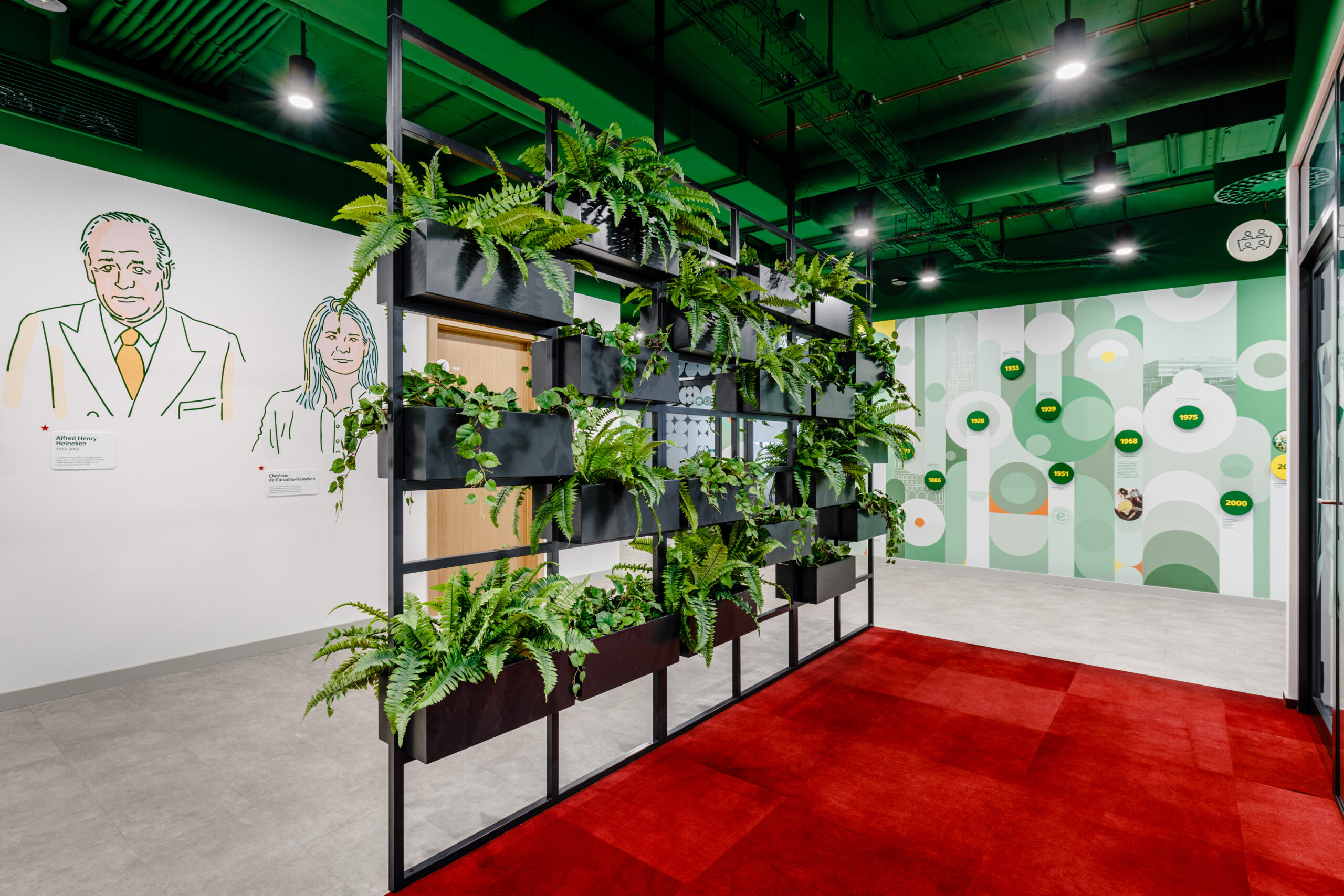 Architektura wnętrza nowego biura, którego centralnym punktem są murale i roślinność.